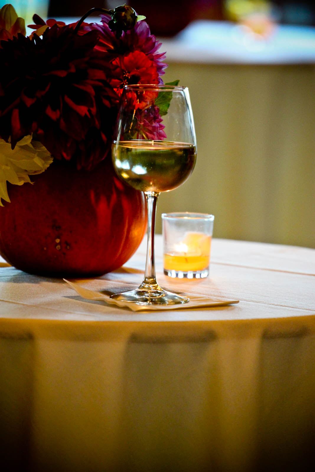 Close-up of a wine glass on a table, white linens, flowers
