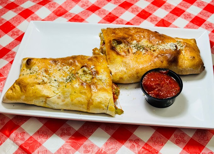 A perfectly toasted Stromboli, hot from the oven, served with marinara for dipping