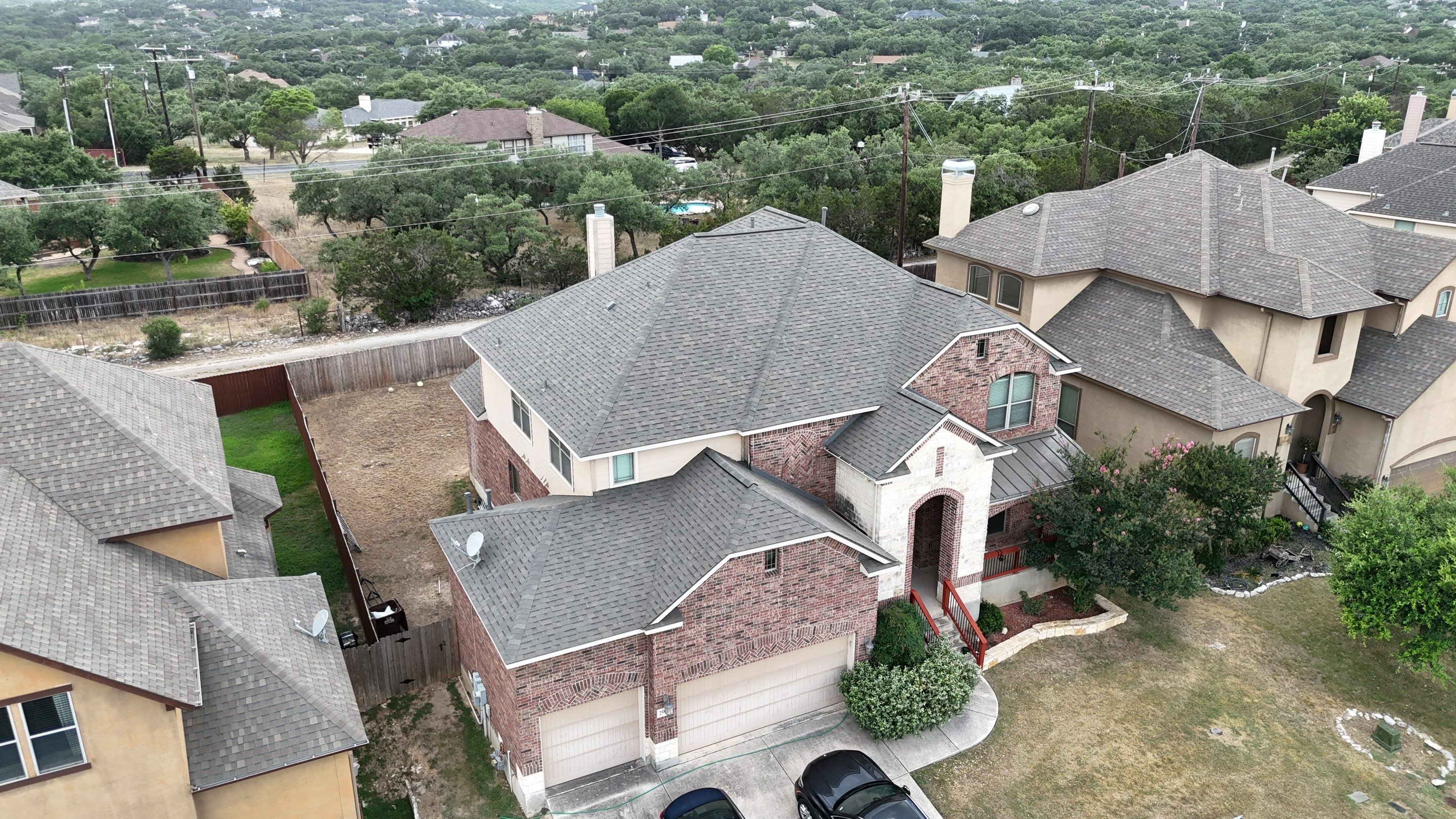 An overhead view of a metal roof on two barns and a round grain silo.