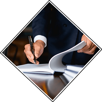 A man wearing a suit signs papers