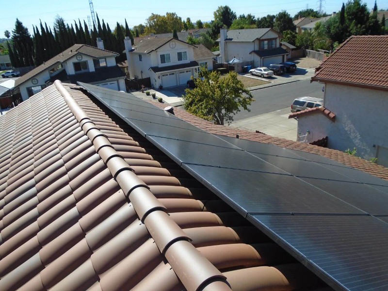 Two rows of solar panels are seen on one side clay tile roof.