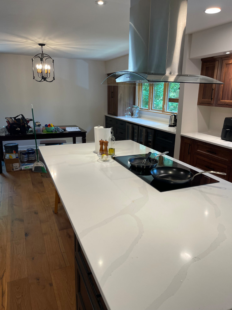 A long kitchen island with white quartz countertop.