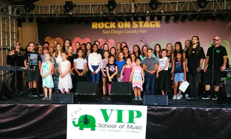 A group of young musicians poses for a photo on stage.