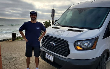A man stands next to a white commercial van.