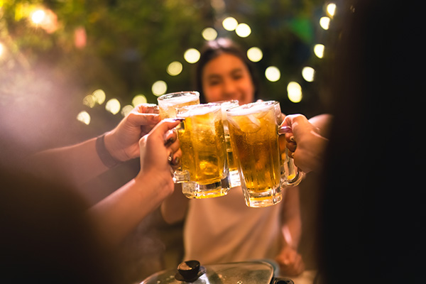 young people clinking pints of beer in a toast