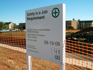 An outdoor sign on white wooden posts for Safety Is a Job Requirement.