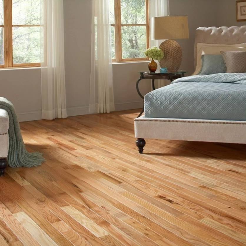 A bedroom with natural wood flooroing