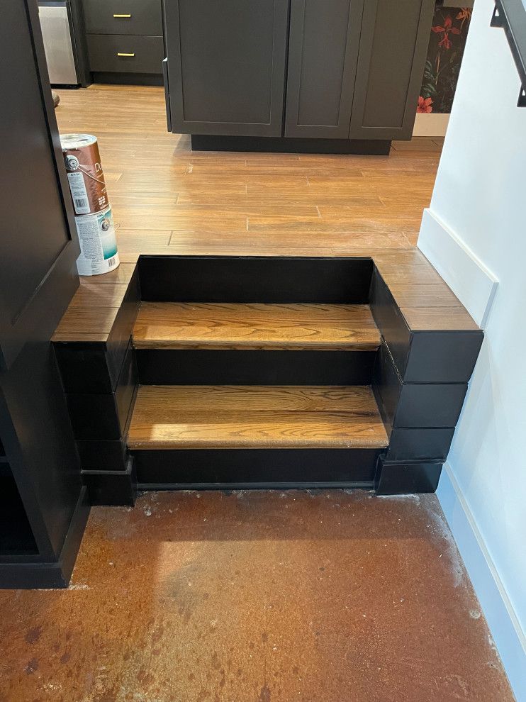 Three wooden steps lead up into a kitchen.
