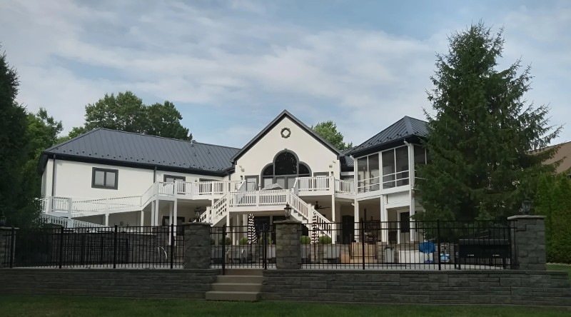 A home with a large, two-level deck with stairway freshly painted.