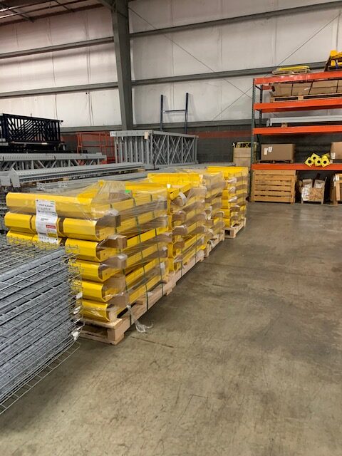 Stacks of pallet racking material sit in a warehouse.