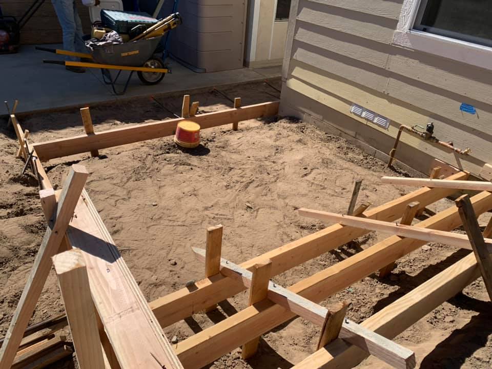 A patio area for a house is sectioned off by boards ready to pour concrete.