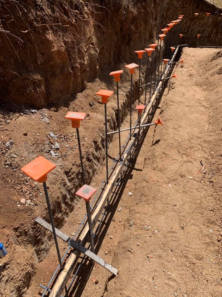 A trench is dug with a guide in place for pouring concrete.