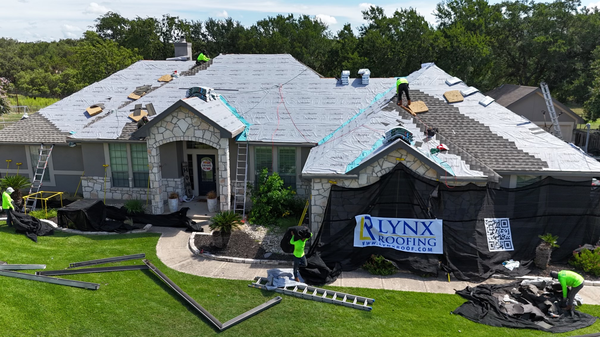 The overhead view of a singled roof with tarp covering sections of damage.