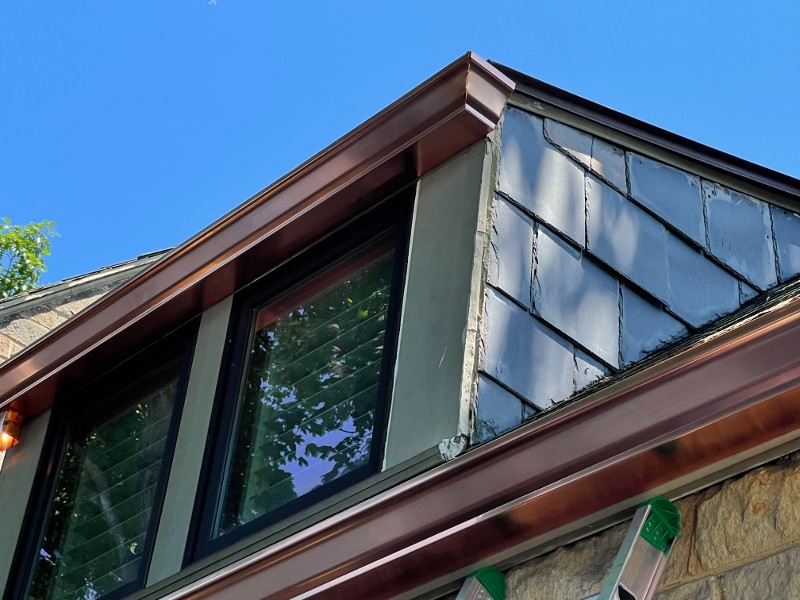 A man installs gutter guard mesh inside a gutter system.