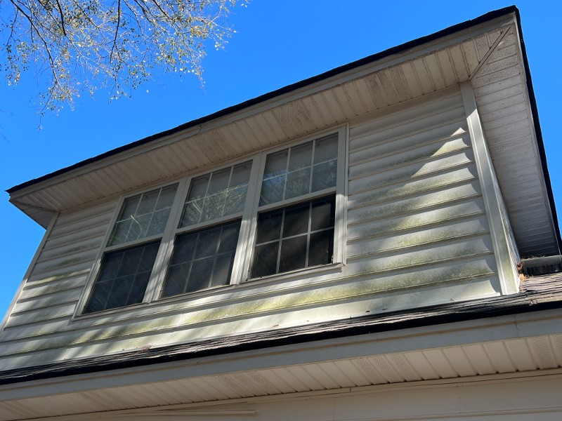 The before view of a house's upper section needing pressure washed.