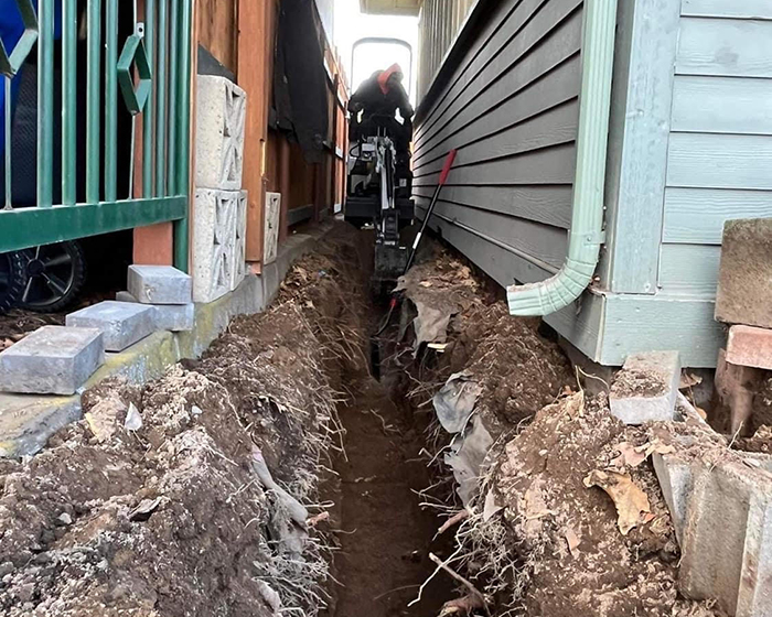 Excavation crews digging up asphalt outside a storage unit.