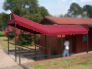 A red awning extends over the walkway entrance to a brick building.