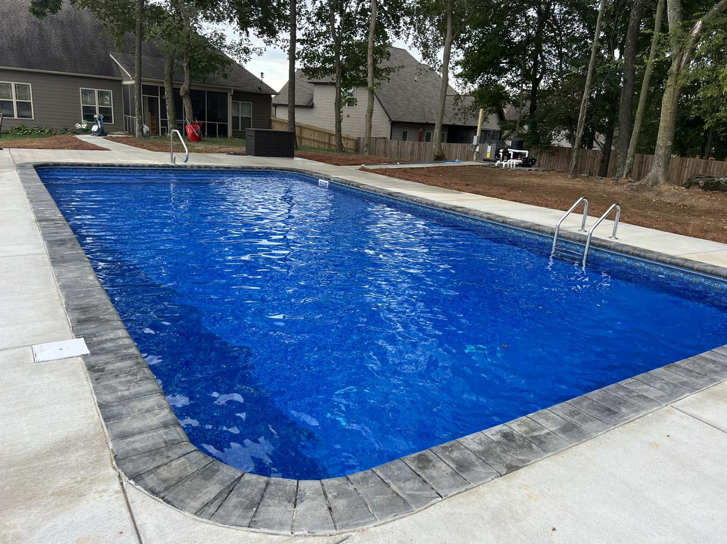 Rectangular in-ground pool with deep blue liner.