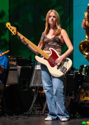 A young girl plays a guitar.