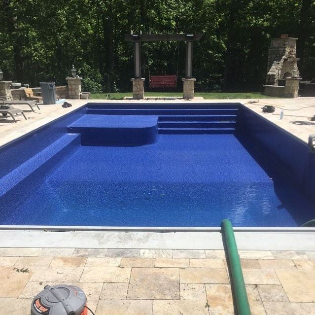 A pool with a blue floor and a five-step entry on the end.