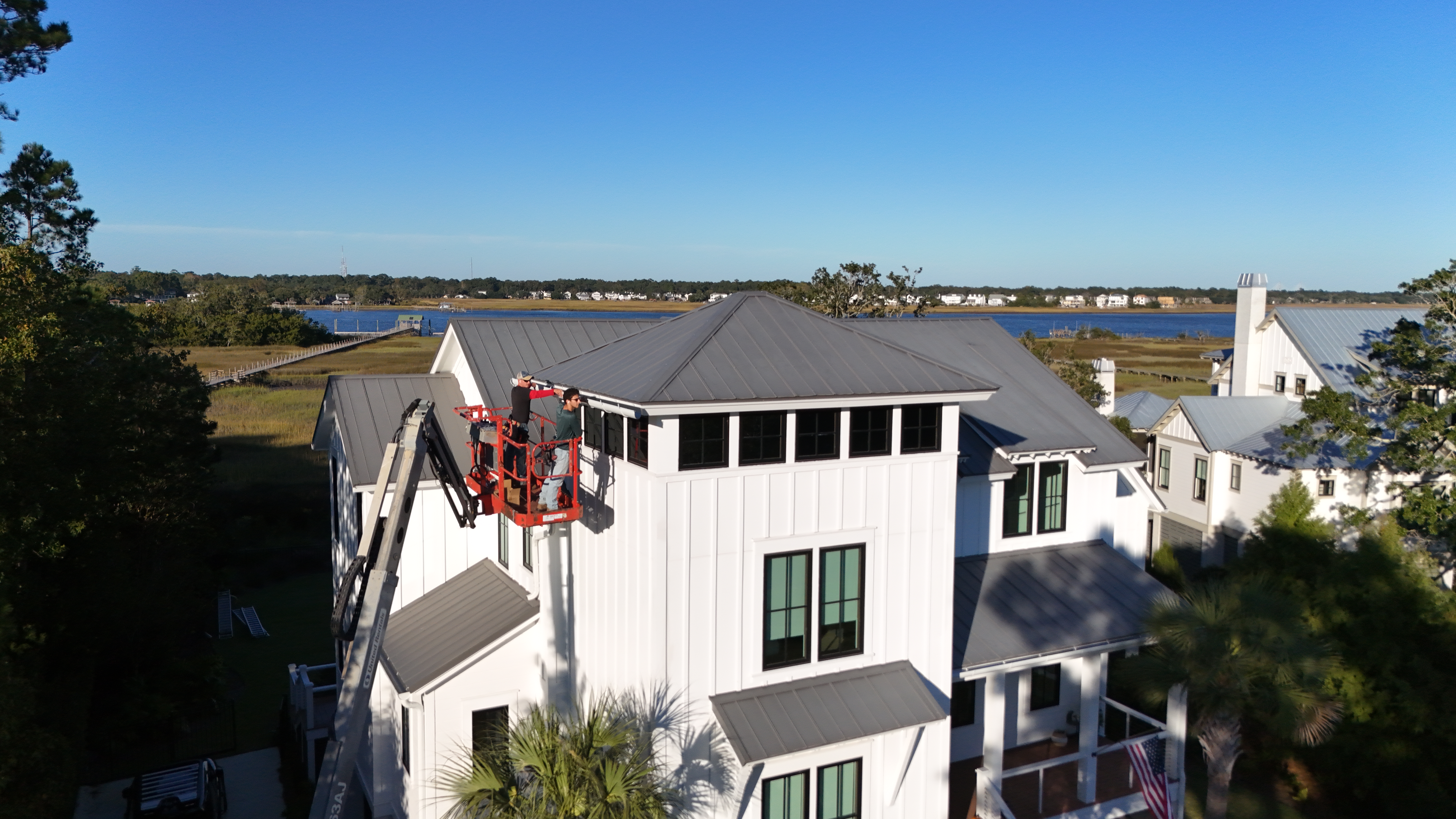 A metal gutter system attached to a shingled roof.