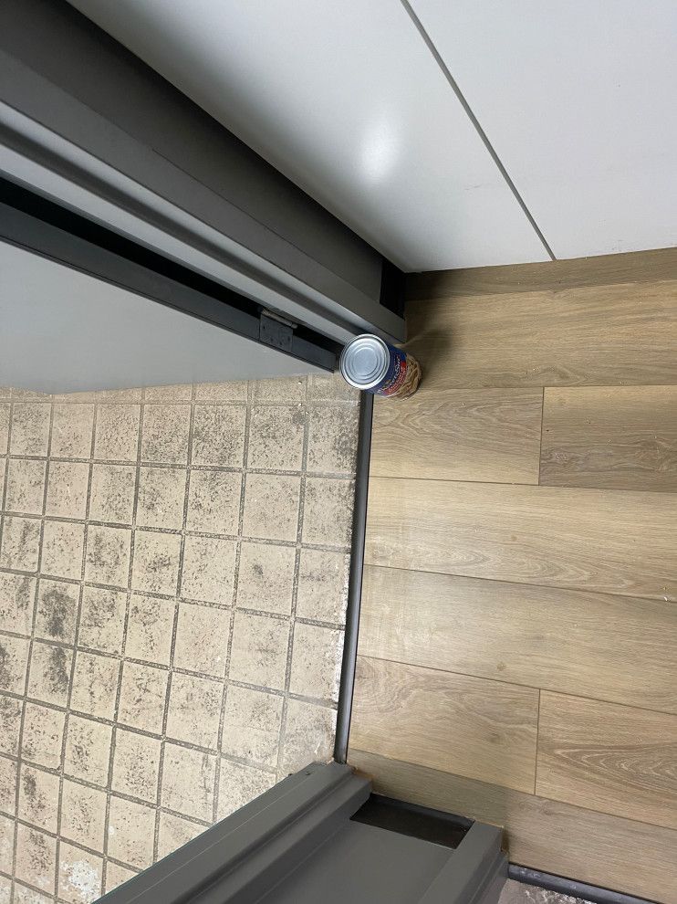 Luxury vinyl flooring leads up to a shower door.