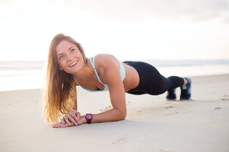 Woman doing a pushup on a beach