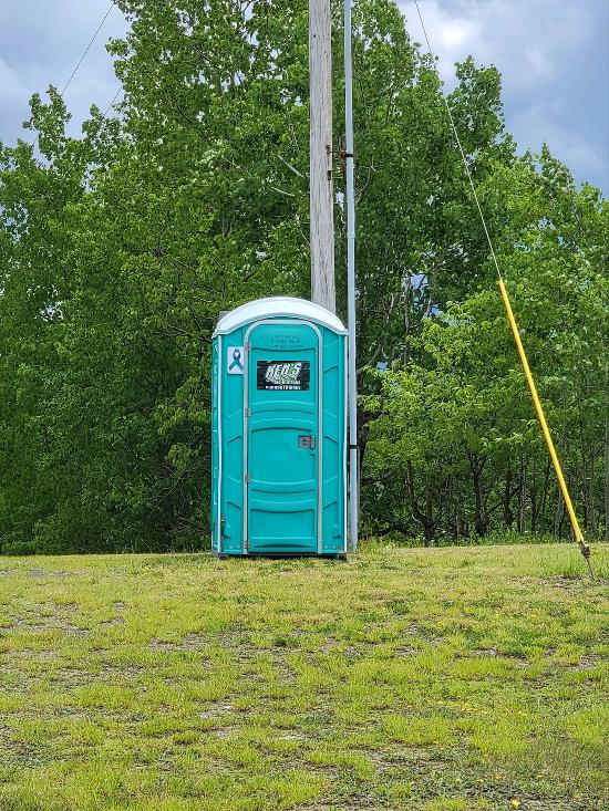 One light green portable toilet.