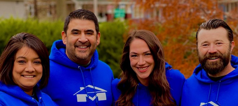 group picture of insurance team wearing blue sweatshirts