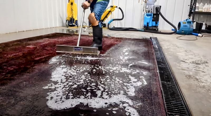 Employee cleaning a rug