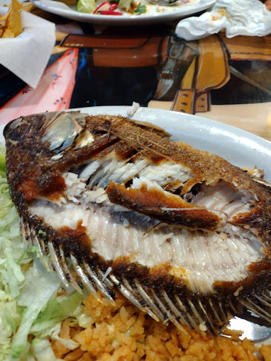 A plate of fried, fileted whole fish.