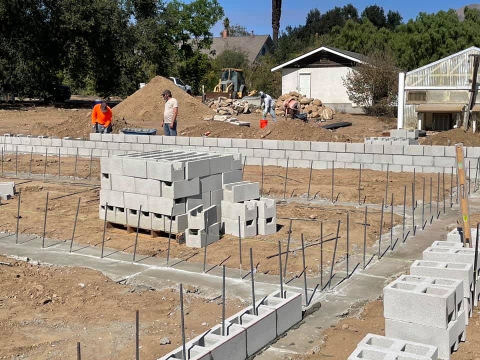 A foundation of a home is laid with rebar and rows of concrete blocks.