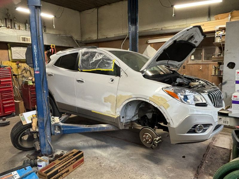 White hatchback receiving body work