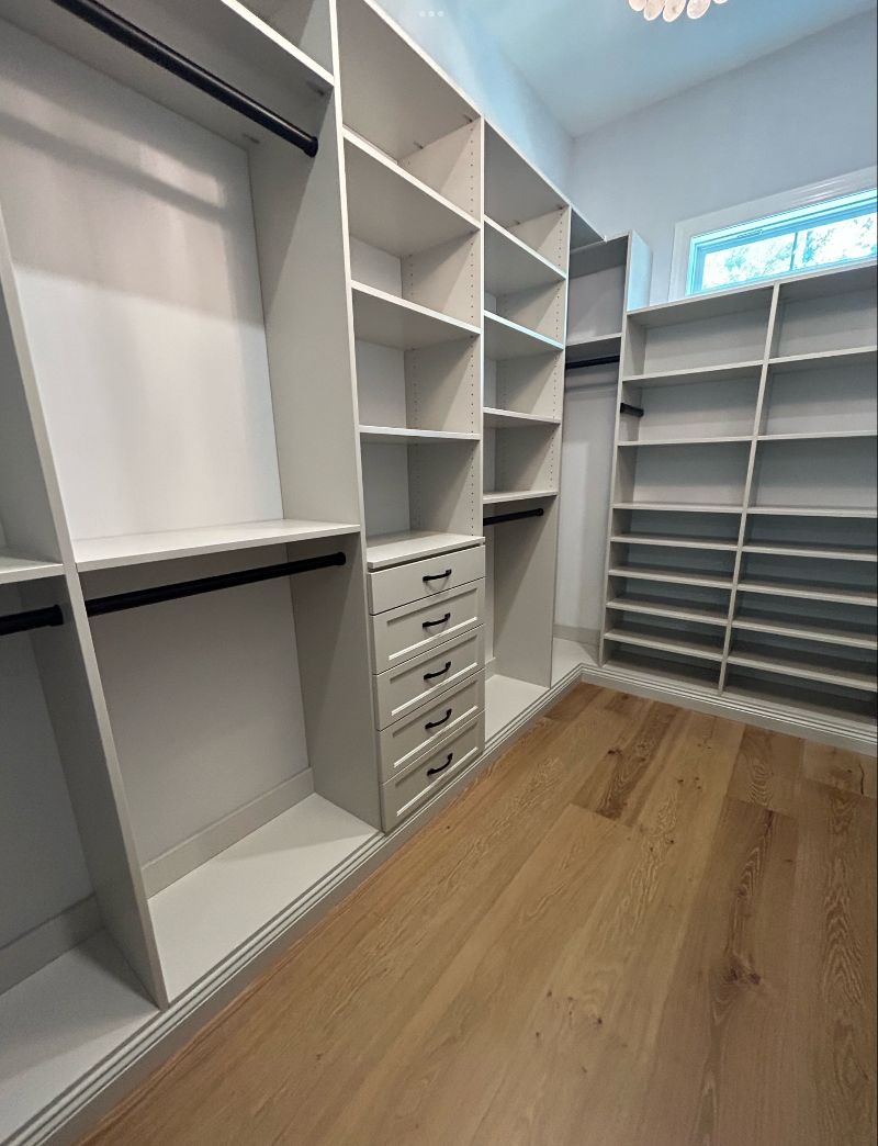 A walk-in closet with the walls lined with open-shelving storage.