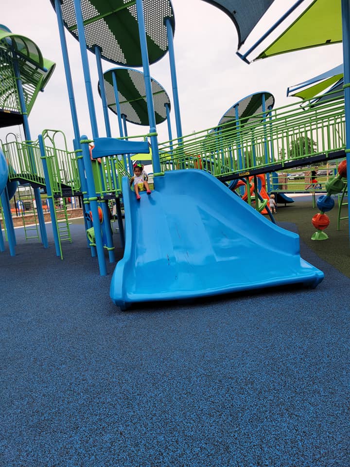 Child going down big blue slide.