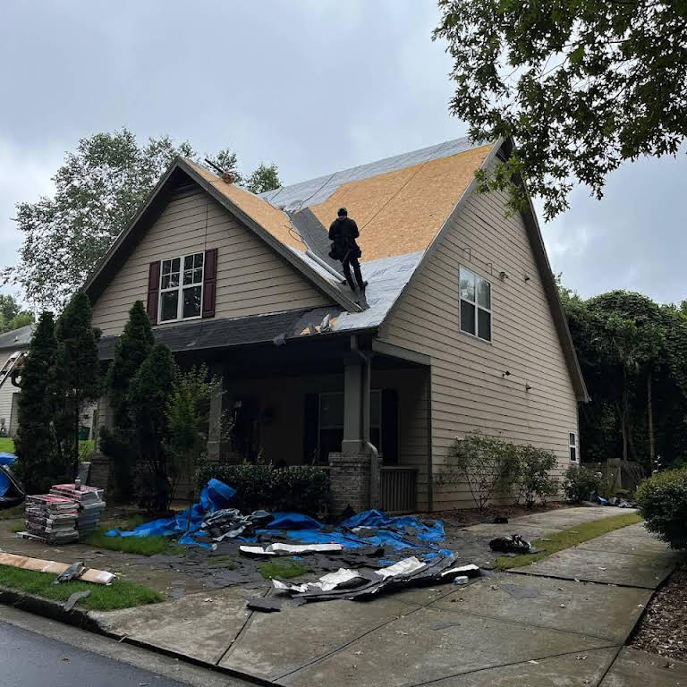 Two-story, single-family home undergoing roofing replacement.