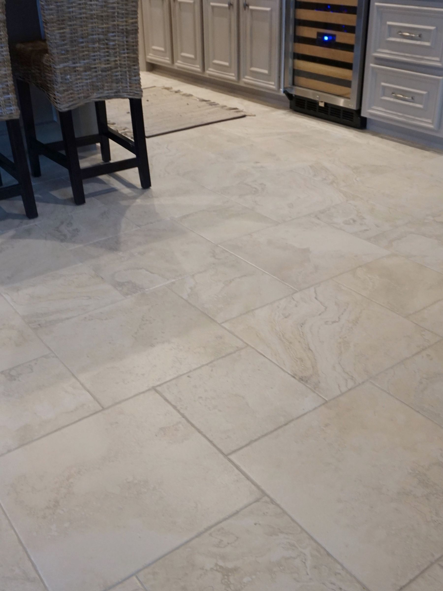 Light-colored tile flooring in different-sized tiles.