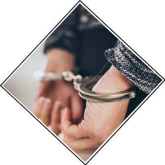 Hands held behind a person's back with handcuffs on the wrists