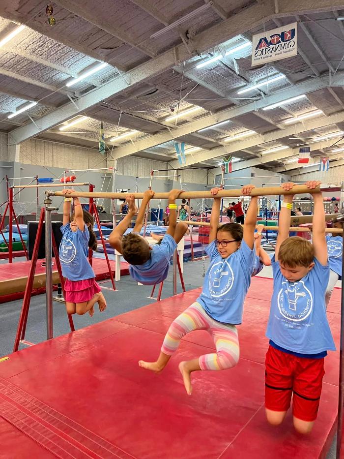 Four kids enjoy gymnastics class.