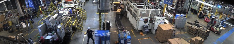 A man stands in a large factory setting.