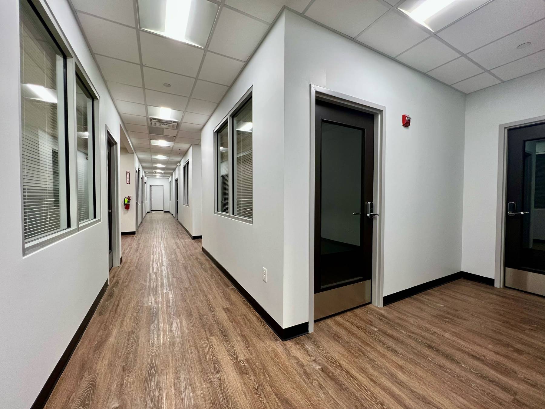 A long hallway with enclosed offices on both sides.