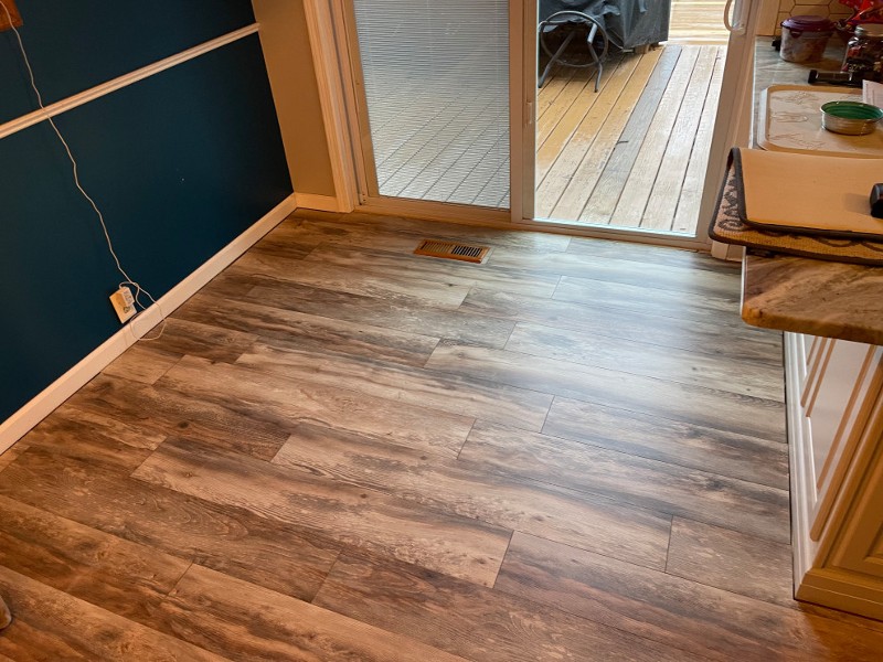 Hardwood flooring is seen leading into another room in a home.