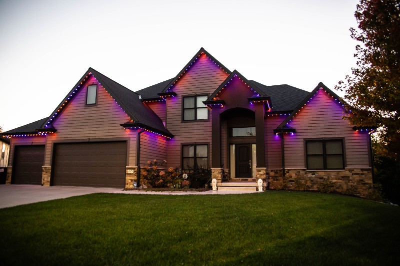 Trimlight lighting set to purple on a brown home.