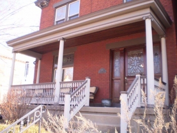 The porch entry to a two-story brick home.