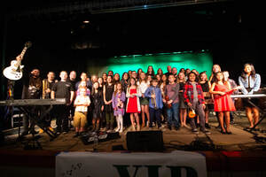 A group of young musicians poses for a photo on stage.