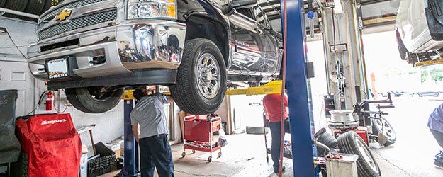 Workers repair a vehicle