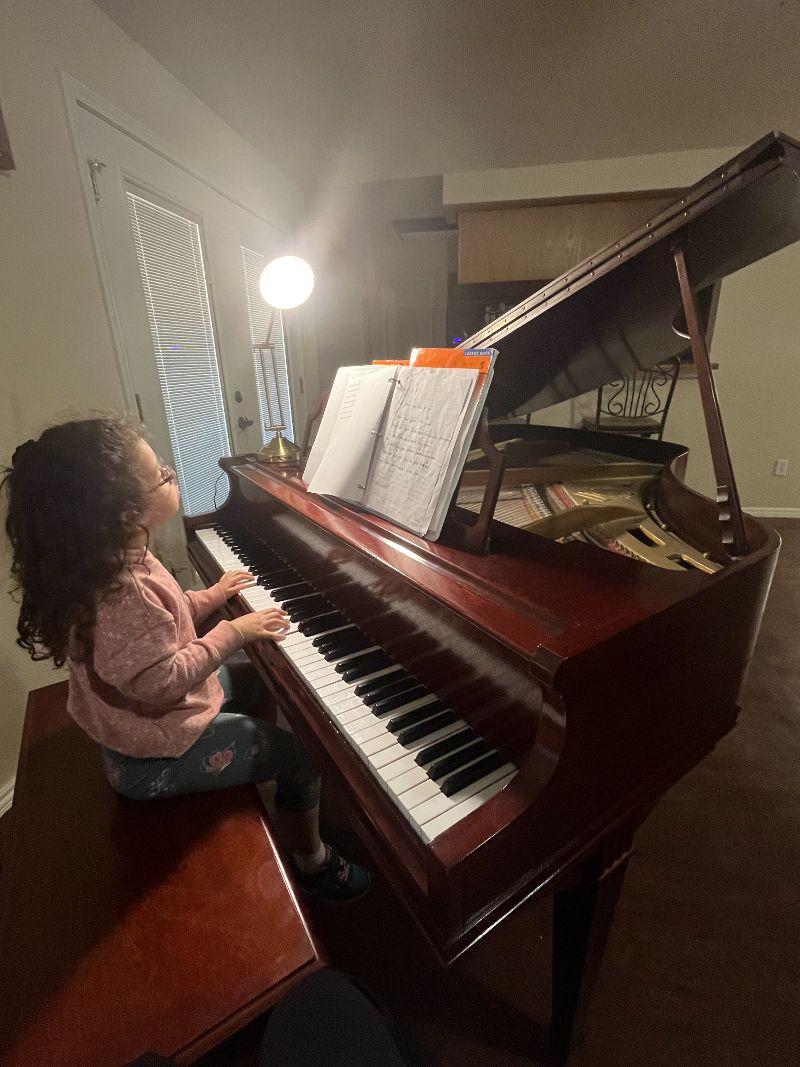 Young girl playing a piano.
