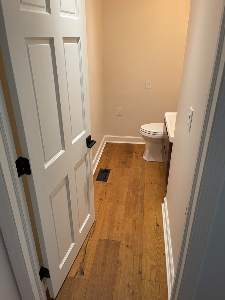 A walkway into a bathroom with new laminate flooring.