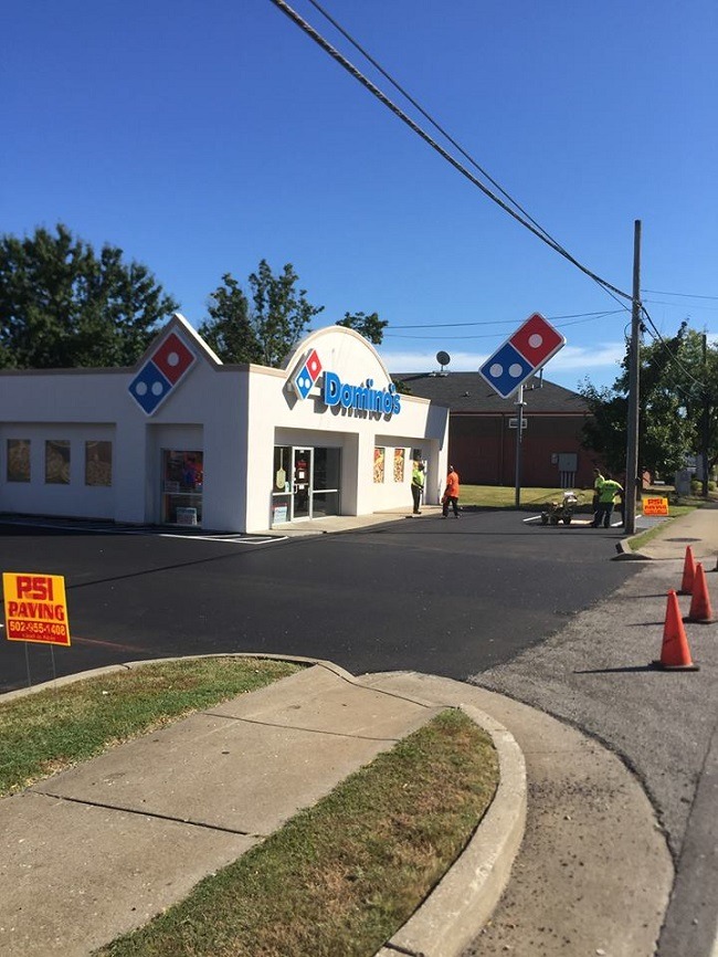 An asphalt parking lot at Domino's Pizza.