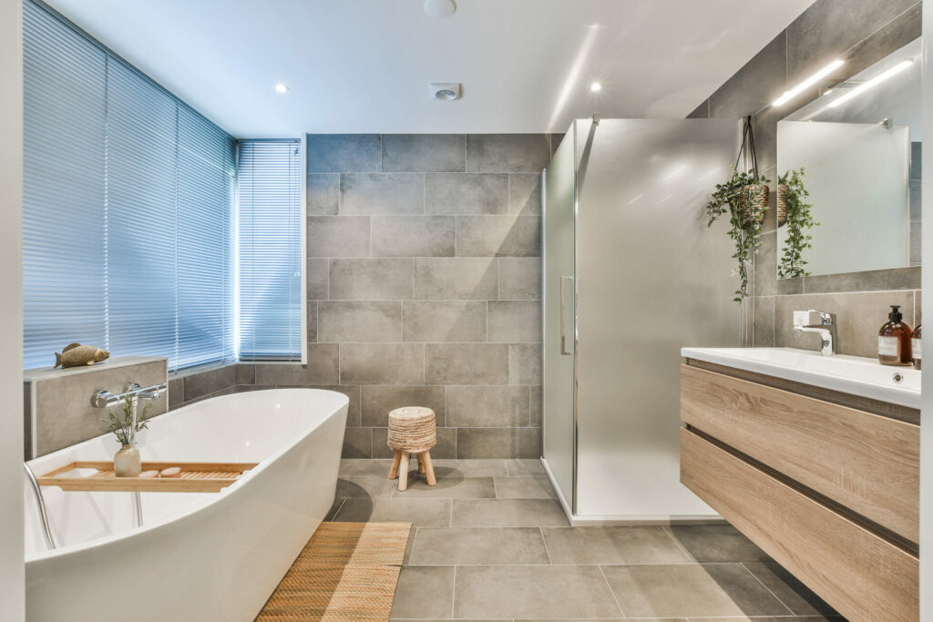 A modern bathroom with a freestanding tub, walk-in shower and double-sink vanity with wooden drawers.